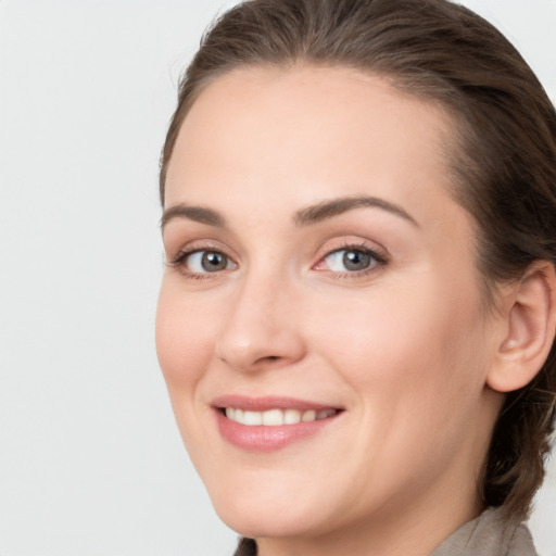 Joyful white young-adult female with medium  brown hair and grey eyes