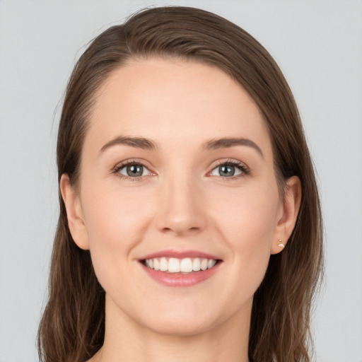 Joyful white young-adult female with long  brown hair and grey eyes