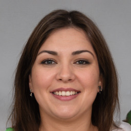 Joyful white young-adult female with medium  brown hair and green eyes