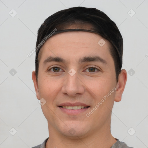 Joyful white young-adult male with short  black hair and brown eyes