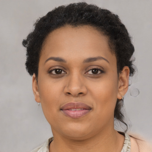 Joyful black adult female with short  brown hair and brown eyes