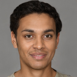 Joyful latino young-adult male with short  brown hair and brown eyes