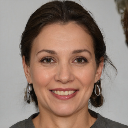 Joyful white adult female with medium  brown hair and brown eyes