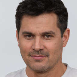 Joyful white adult male with short  black hair and brown eyes