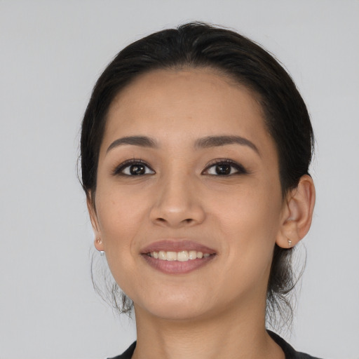 Joyful latino young-adult female with long  black hair and brown eyes