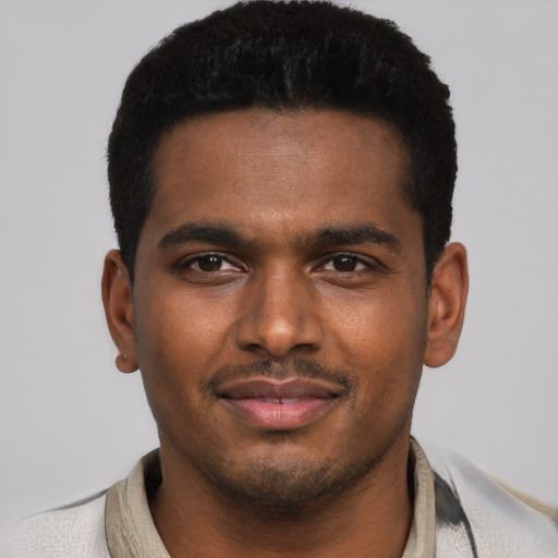 Joyful black young-adult male with short  brown hair and brown eyes