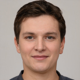 Joyful white young-adult male with short  brown hair and grey eyes