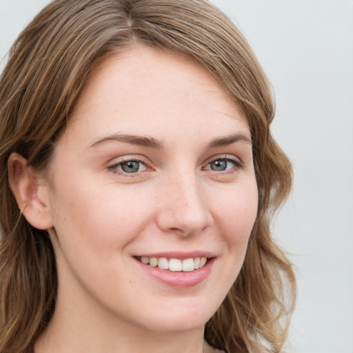 Joyful white young-adult female with long  brown hair and blue eyes