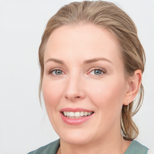 Joyful white young-adult female with medium  brown hair and blue eyes