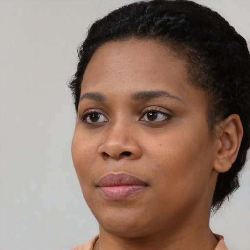 Joyful black young-adult female with short  black hair and brown eyes