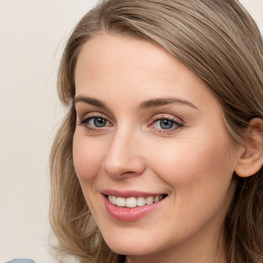 Joyful white young-adult female with long  brown hair and blue eyes