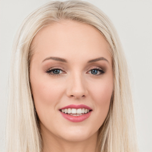 Joyful white young-adult female with long  brown hair and blue eyes