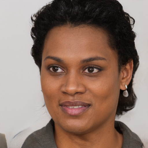 Joyful black young-adult female with short  black hair and brown eyes