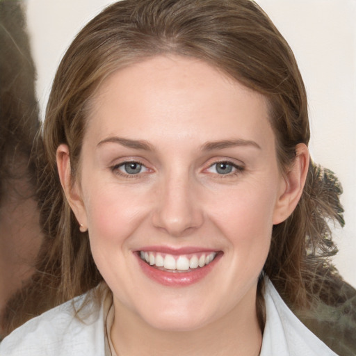 Joyful white young-adult female with medium  brown hair and grey eyes