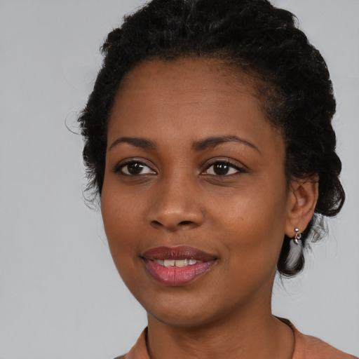 Joyful black young-adult female with medium  brown hair and brown eyes