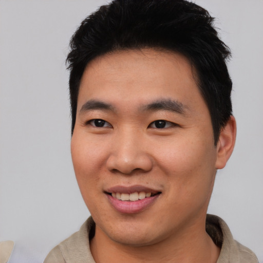 Joyful asian young-adult male with short  black hair and brown eyes