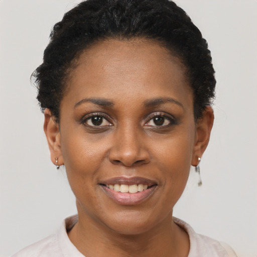 Joyful black young-adult female with short  brown hair and brown eyes
