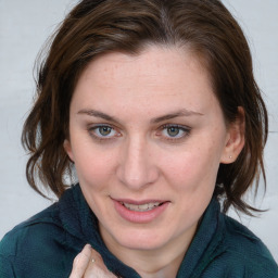 Joyful white young-adult female with medium  brown hair and blue eyes