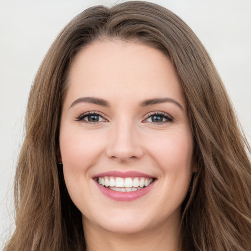 Joyful white young-adult female with long  brown hair and green eyes