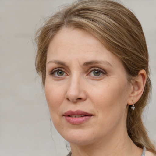 Joyful white adult female with medium  brown hair and grey eyes