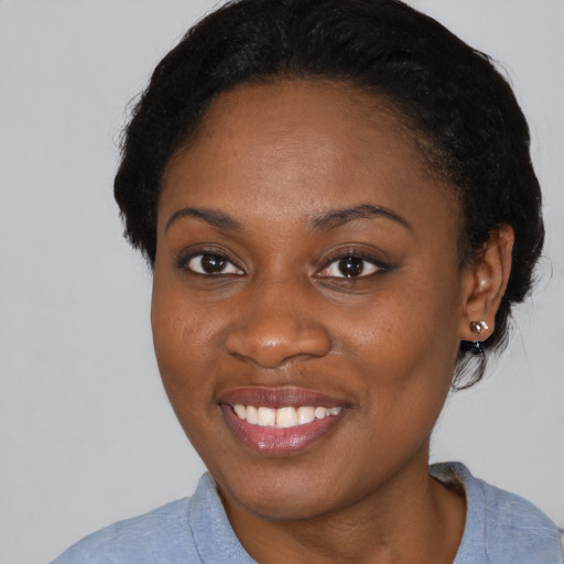 Joyful black young-adult female with short  black hair and brown eyes