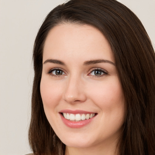 Joyful white young-adult female with long  brown hair and brown eyes