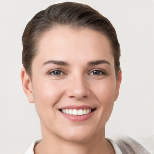 Joyful white young-adult female with short  brown hair and grey eyes