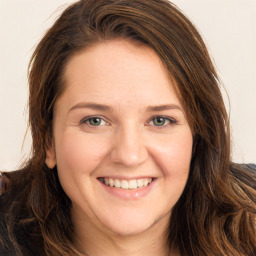 Joyful white young-adult female with long  brown hair and green eyes