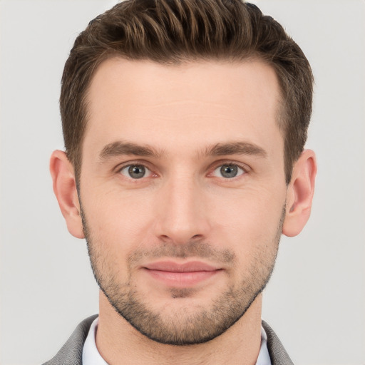 Joyful white young-adult male with short  brown hair and grey eyes