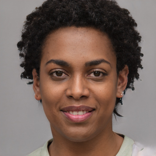 Joyful black young-adult female with short  black hair and brown eyes
