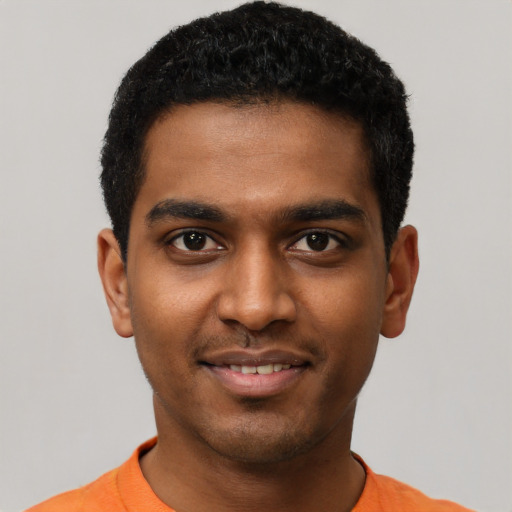 Joyful black young-adult male with short  black hair and brown eyes