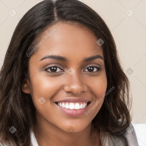 Joyful black young-adult female with long  brown hair and brown eyes