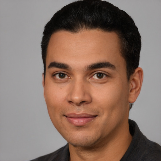 Joyful latino young-adult male with short  black hair and brown eyes