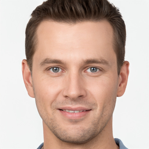 Joyful white young-adult male with short  brown hair and grey eyes