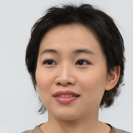 Joyful asian young-adult female with medium  brown hair and brown eyes