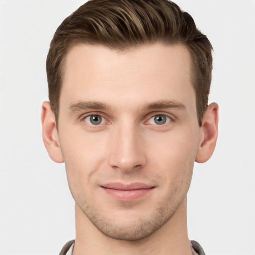 Joyful white young-adult male with short  brown hair and grey eyes