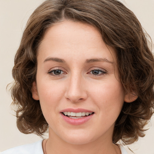 Joyful white young-adult female with medium  brown hair and green eyes