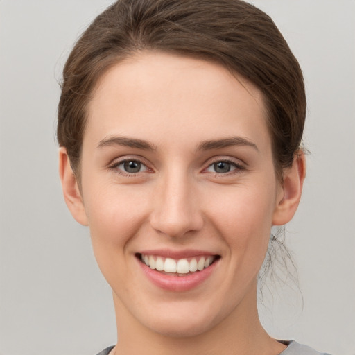 Joyful white young-adult female with short  brown hair and grey eyes