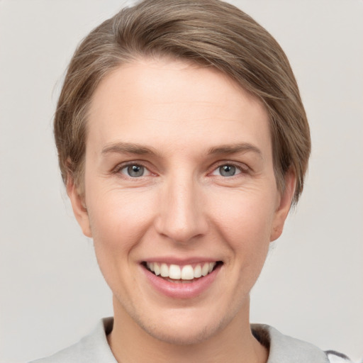 Joyful white young-adult female with short  brown hair and grey eyes