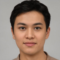 Joyful asian young-adult male with short  brown hair and brown eyes