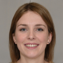 Joyful white young-adult female with medium  brown hair and grey eyes