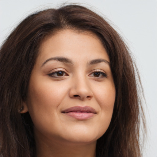 Joyful latino young-adult female with long  brown hair and brown eyes