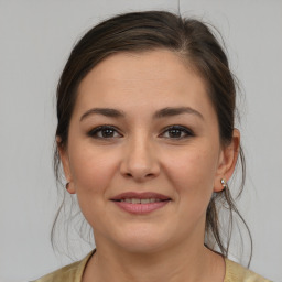 Joyful white young-adult female with medium  brown hair and brown eyes