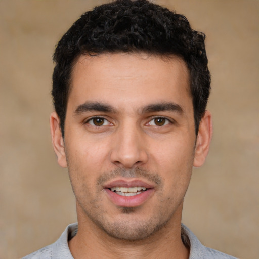 Joyful white young-adult male with short  black hair and brown eyes