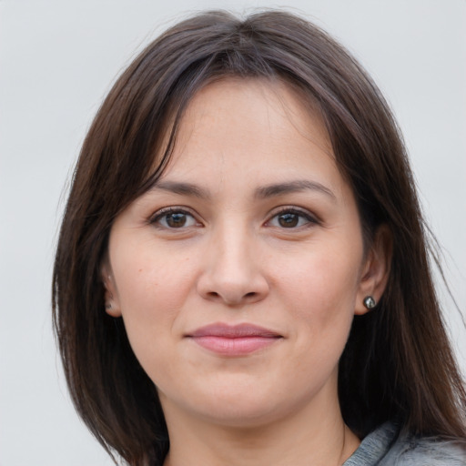 Joyful white young-adult female with medium  brown hair and grey eyes