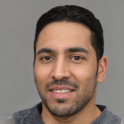 Joyful white young-adult male with short  black hair and brown eyes