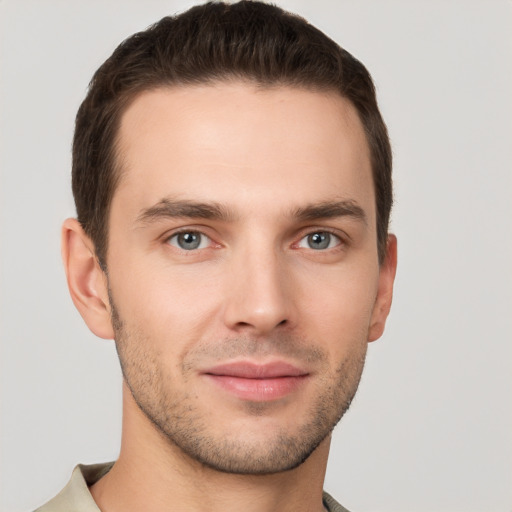 Joyful white young-adult male with short  brown hair and grey eyes