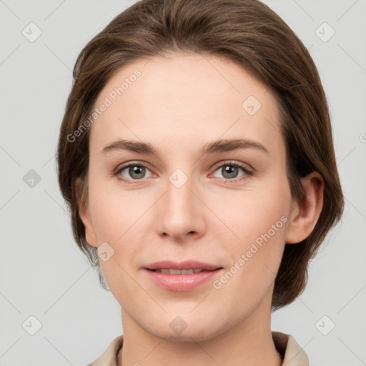 Joyful white young-adult female with medium  brown hair and grey eyes