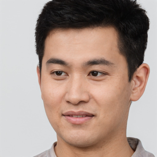 Joyful asian young-adult male with short  black hair and brown eyes