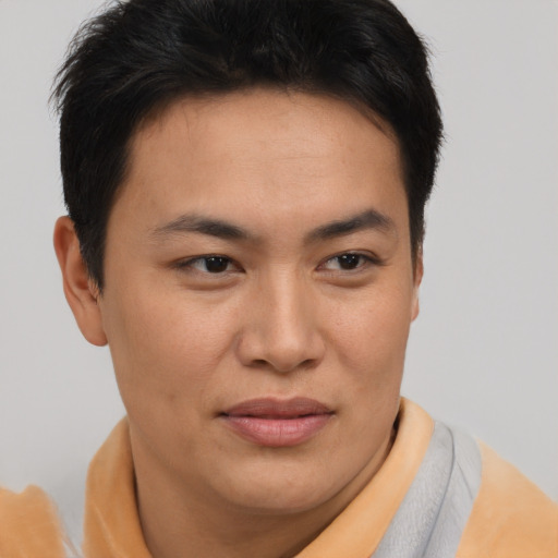 Joyful asian young-adult male with short  brown hair and brown eyes